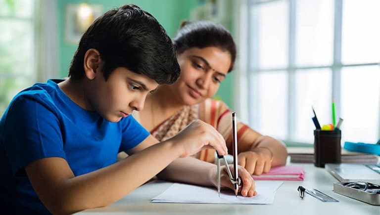 Student solving Maths problem on whiteboard during personalised group tuition at Usha Tutorials Kharegaon